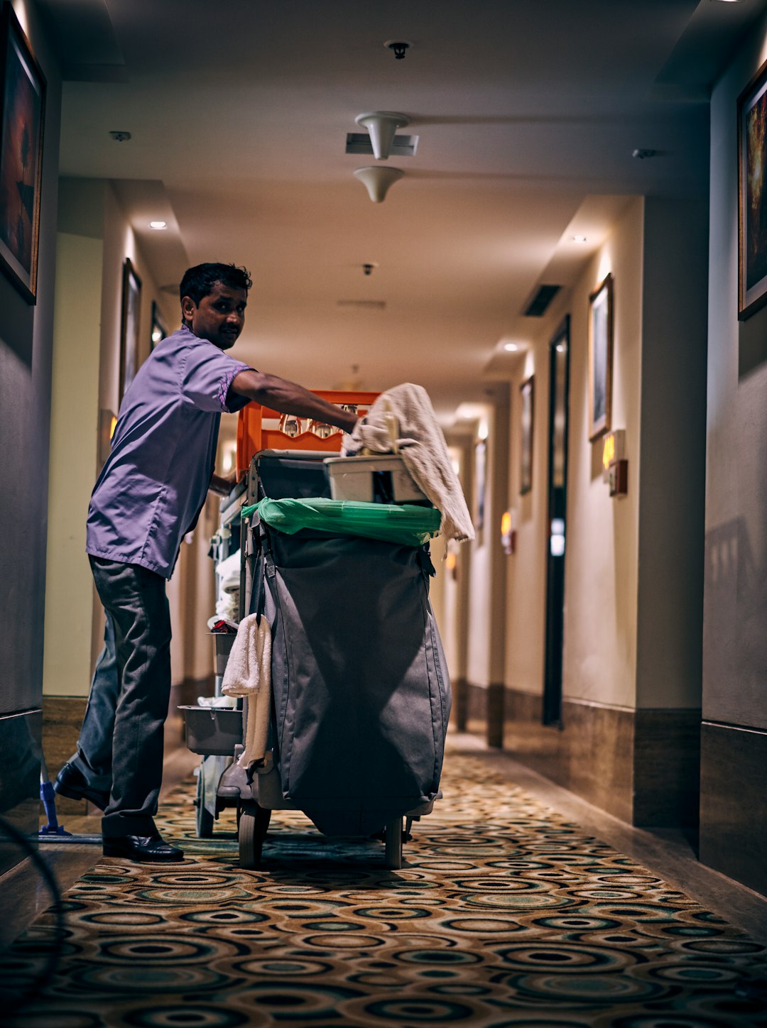 services-01 Room cleaning person in a hotel hallway with his equipments