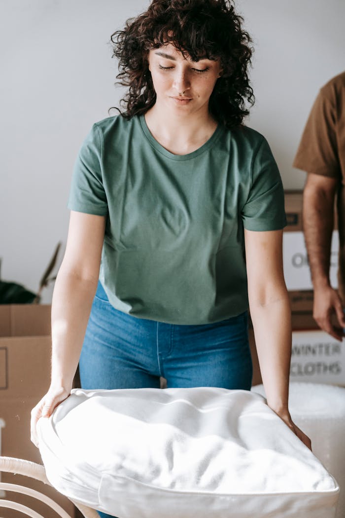 services-03 A woman packing cushions for relocation indoors, symbolizing a moving day scene.